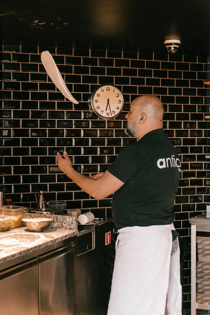Le pizzaiolo enfournant une pizza